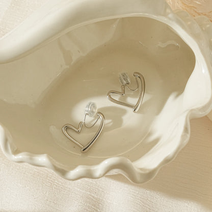 Side profile of silver heart hoop showing the adjustable clip-on mechanism and hollow lightweight design.