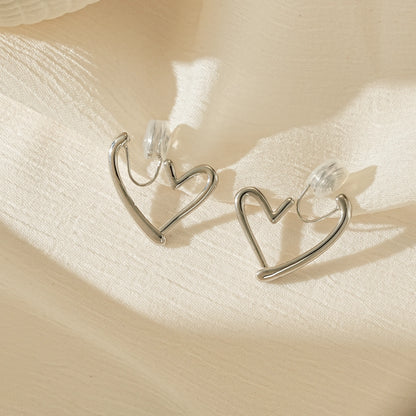 Polished silver chunky heart hoop clip-on earrings, front view showing the bold shape for unpierced ears.